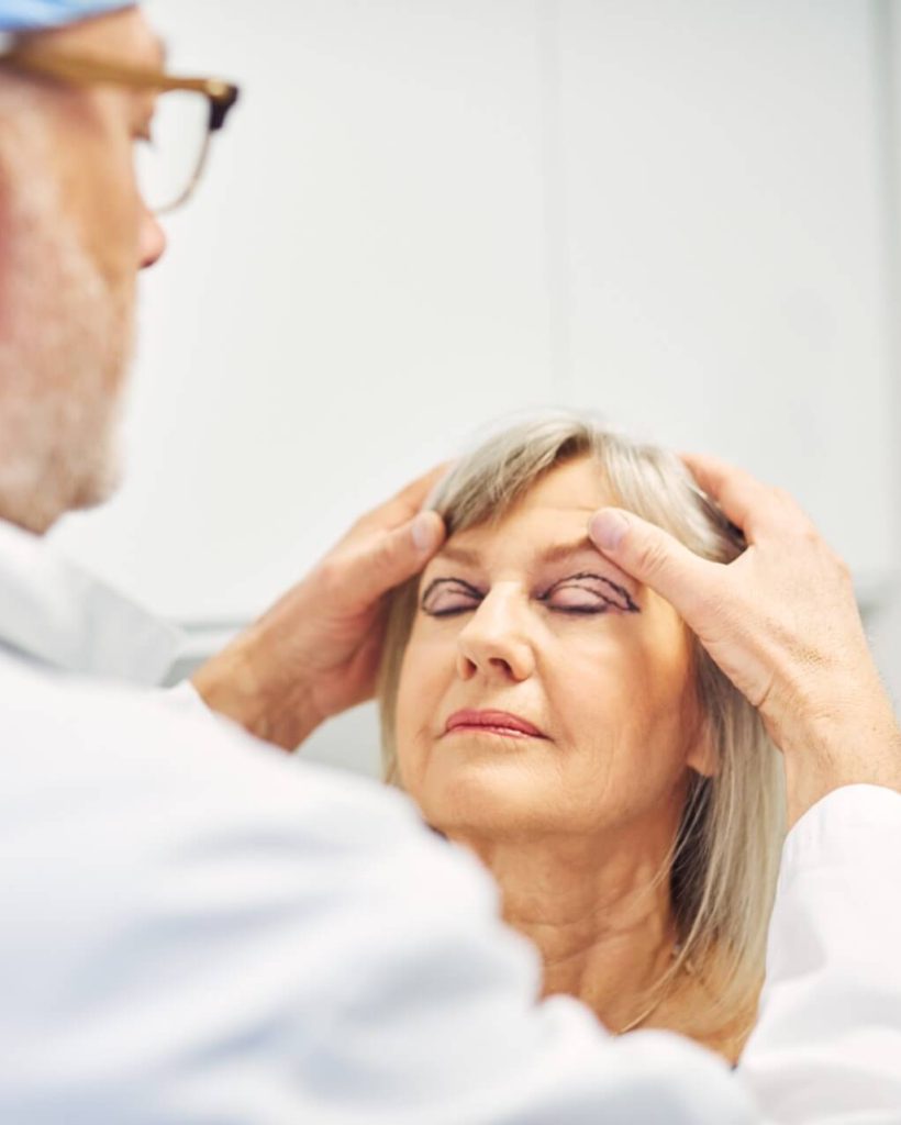 cosmetics-surgeon-holding-adult-woman-head-and-dia-2021-08-27-09-27-41-utc.jpg